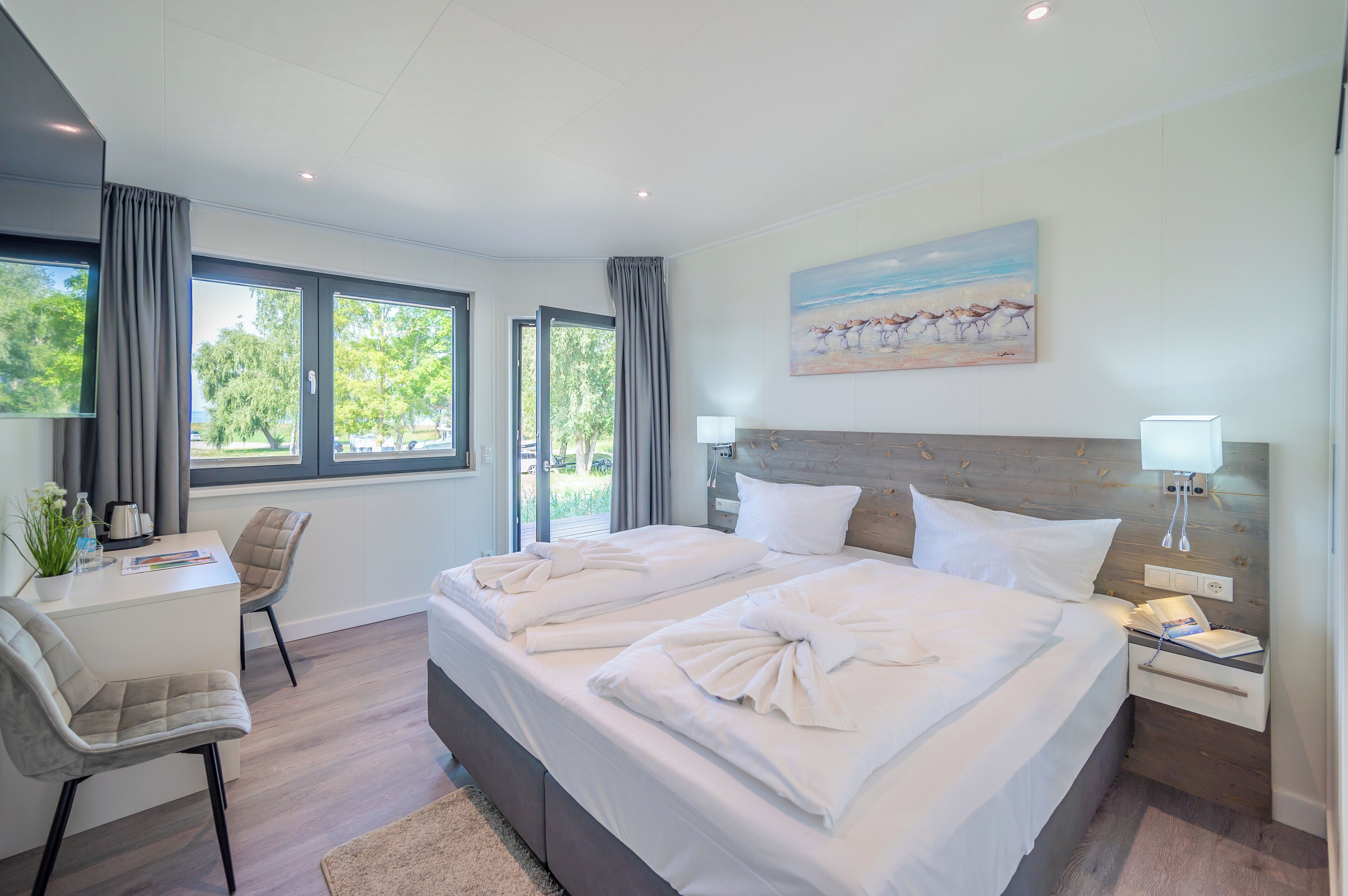 Une chambre d’hôtel moderne avec deux lits, un bureau et une chaise.