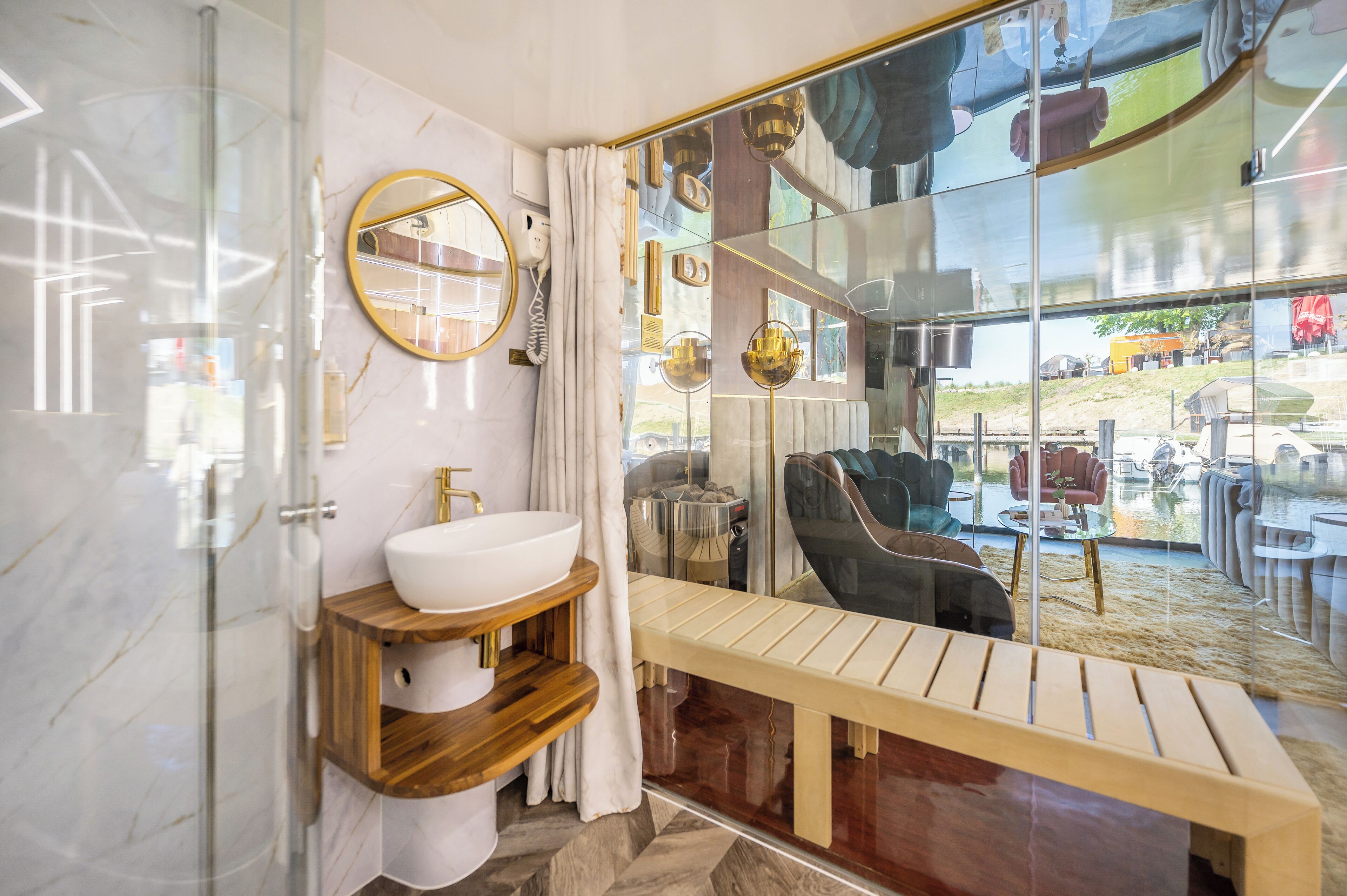 A modern bathroom with a glass shower enclosure, a wooden vanity with a white sink, and a large mirror.