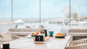 Une table en bois dressée pour le petit-déjeuner, avec un numéro 1, un croissant, un bol et une tasse.