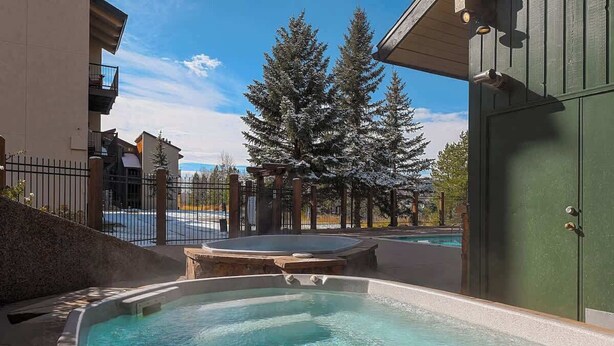 A hot tub area with a pool, surrounded by a fence and trees. - Rocky Mountain Sanctuary (Steamboat Springs)