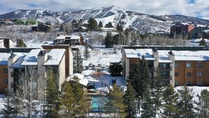 A resort with multiple buildings, a pool, and a snowy mountain backdrop. - Rocky Mountain Sanctuary (Steamboat Springs)