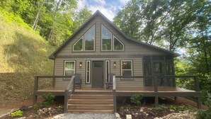 A two-story house with a front porch, a staircase, and a deck.