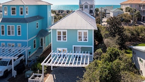 A coastal property with a two-story house, a covered patio, and a view of the ocean. - 30A Beach House ~ Gulf Views ~ Gated Beach Access (Seacrest Beach)