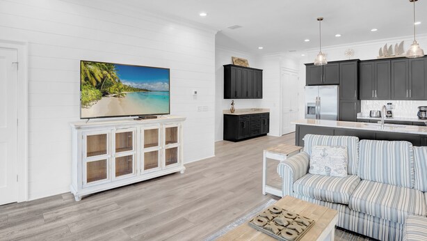 A modern kitchen with dark cabinets, a white countertop, and pendant lighting. - West Side Cottages CC by Liquid Life (Gulf Shores)