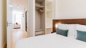 Un dormitorio con cama, armario y mesita de noche.