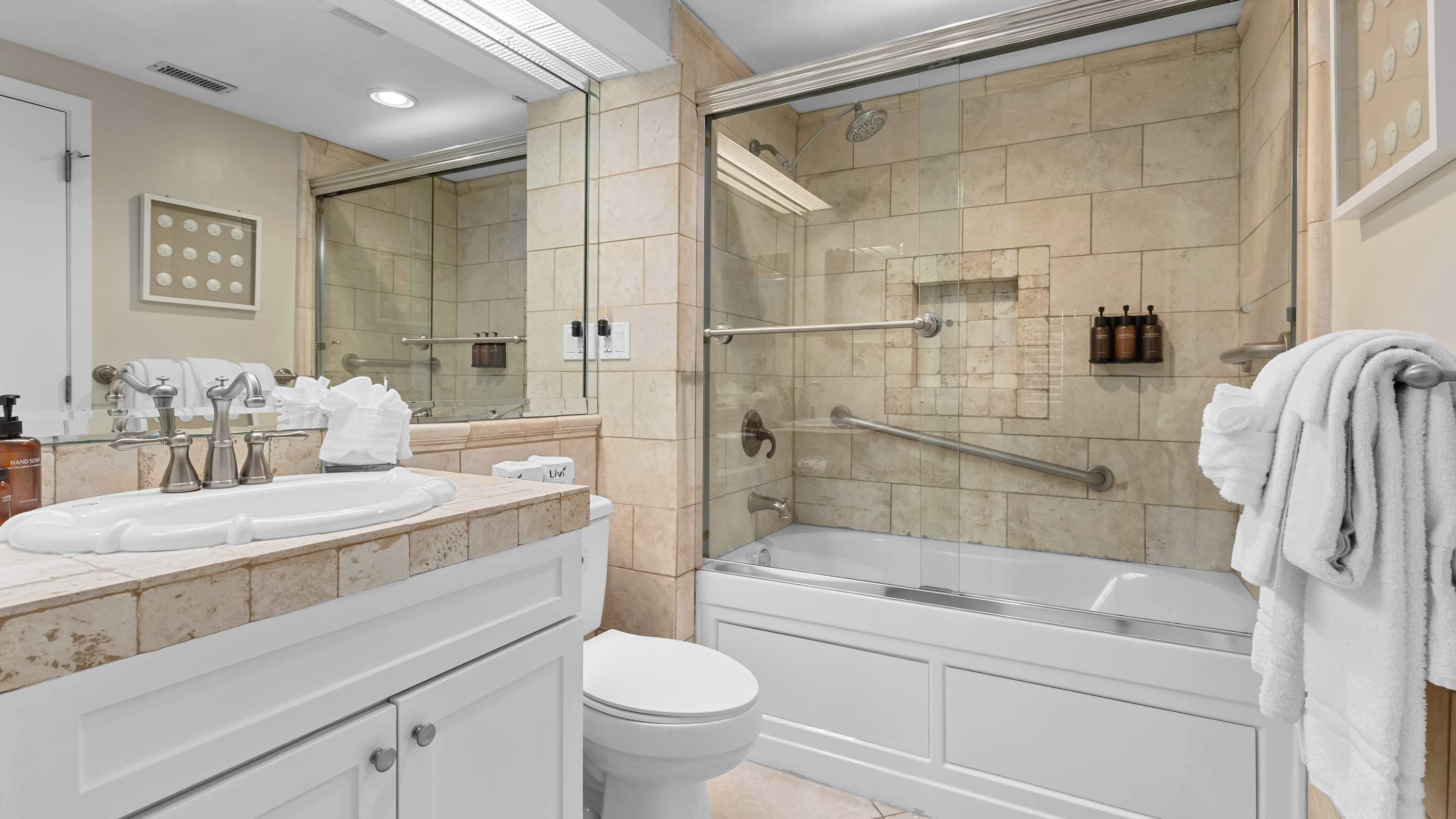 Une salle de bain moderne dotée d’une douche à parois de verre, d’une baignoire séparée et d’un meuble-lavabo avec un grand miroir.