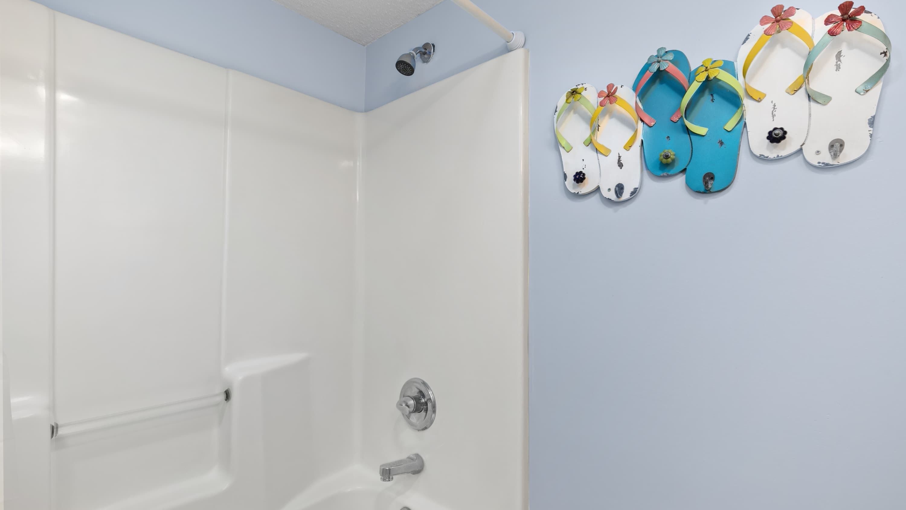 A bathroom with a white bathtub, a shower, and a toilet.