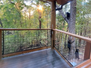 A wooden deck with a metal railing overlooking a forested area. - Arcade | Private Hot Tub | Firepit | Fireplace | Close to Attractions (Sevierville)