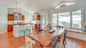 Cocina amplia con una isla grande, armarios de madera y vistas al exterior.