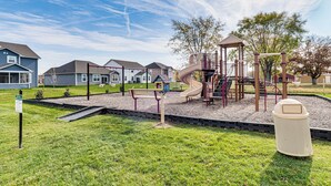 A playground with a slide, climbing structures, and a small house. - 5 Mi to Fort Harrison: Home w/ Pool Access! (McCordsville)