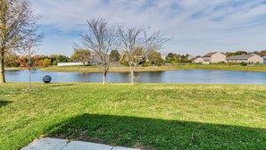 A grassy area with a pond, trees, and houses in the background. - 5 Mi to Fort Harrison: Home w/ Pool Access! (McCordsville)
