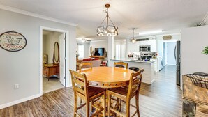 Una cocina amplia con una isla central, una mesa de comedor de madera y sillas.