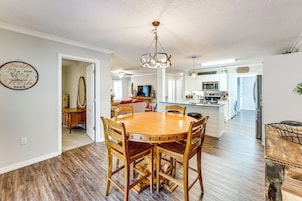 Una cocina amplia con una isla central, una mesa de comedor de madera y sillas.