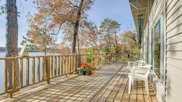 Relax on the lakeside deck with outdoor furniture and a view of the surrounding landscape.