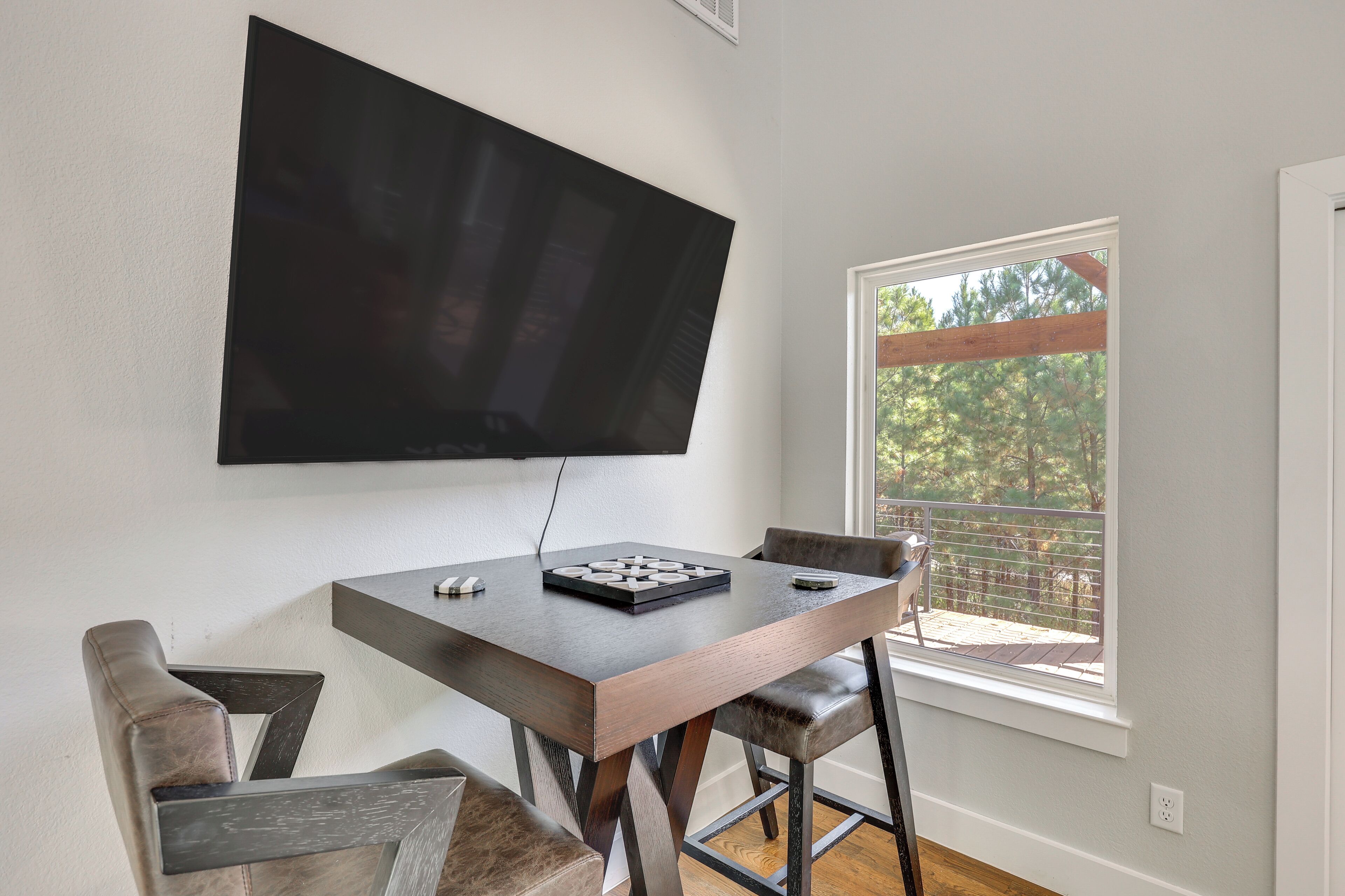 Un espace repas comprenant une table, des chaises et un téléviseur à écran plat fixé au mur.