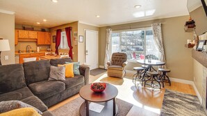 A living room with a sofa, coffee table, and a dining area with a table and chairs. - Walk to Giant Steps & Hot Tub: Brian Head Condo! (Brian Head)