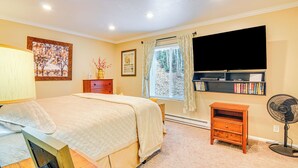 A bedroom with a bed, bedside table, lamp, window with curtains, and a wall-mounted TV. - Walk to Giant Steps & Hot Tub: Brian Head Condo! (Brian Head)