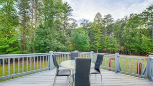 A wooden deck with a round table and four chairs, surrounded by a railing, overlooking a forested area. - Group Getaway ~ 15 Mi to Charlottesville! (Troy)