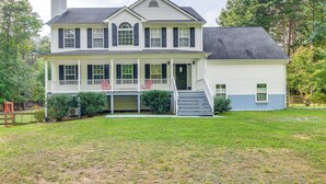 A two-story house with a front porch, a chimney, and a well-maintained lawn. - Group Getaway ~ 15 Mi to Charlottesville! (Troy)