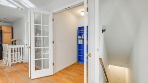 A room with a wooden floor, white walls, a white door with glass panels, a blue shelving unit, and a white ceiling light. - Group Getaway ~ 15 Mi to Charlottesville! (Troy)