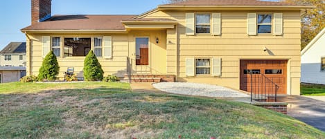 A two-story house with a front porch, a garage, and a well-maintained lawn.