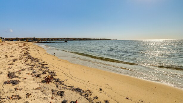 A beach with a clear sky and calm sea.