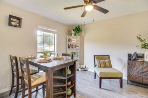 A dining area with a wooden table, chairs, and a ceiling fan. - Patio for Al Fresco Dining: Home in Hinesville! (Hinesville)