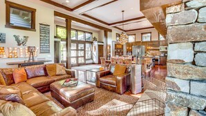 A spacious living area with leather sofas, a coffee table, and a stone accent wall. - Golf Getaway w/ Hot Tub, Course Views in Cle Elum! (Cle Elum)