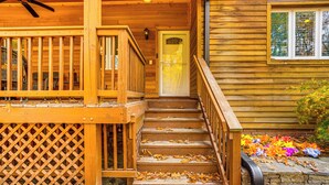 A wooden cabin with a porch, a staircase, and a stone wall. - Private Hot Tub on 10 Acres: Cozy Catskill Getaway (Catskill)