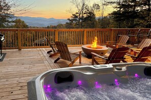 A wooden deck with a hot tub, chairs, and a fire pit. - 3 Mi to Dtwn: Mtn-view Cabin in Gatlinburg! (Gatlinburg)