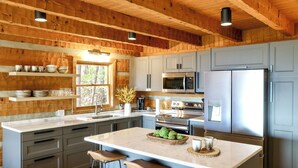 A modern kitchen with grey cabinets, stainless steel appliances, and a large island with stools. - 3 Mi to Dtwn: Mtn-view Cabin in Gatlinburg! (Gatlinburg)