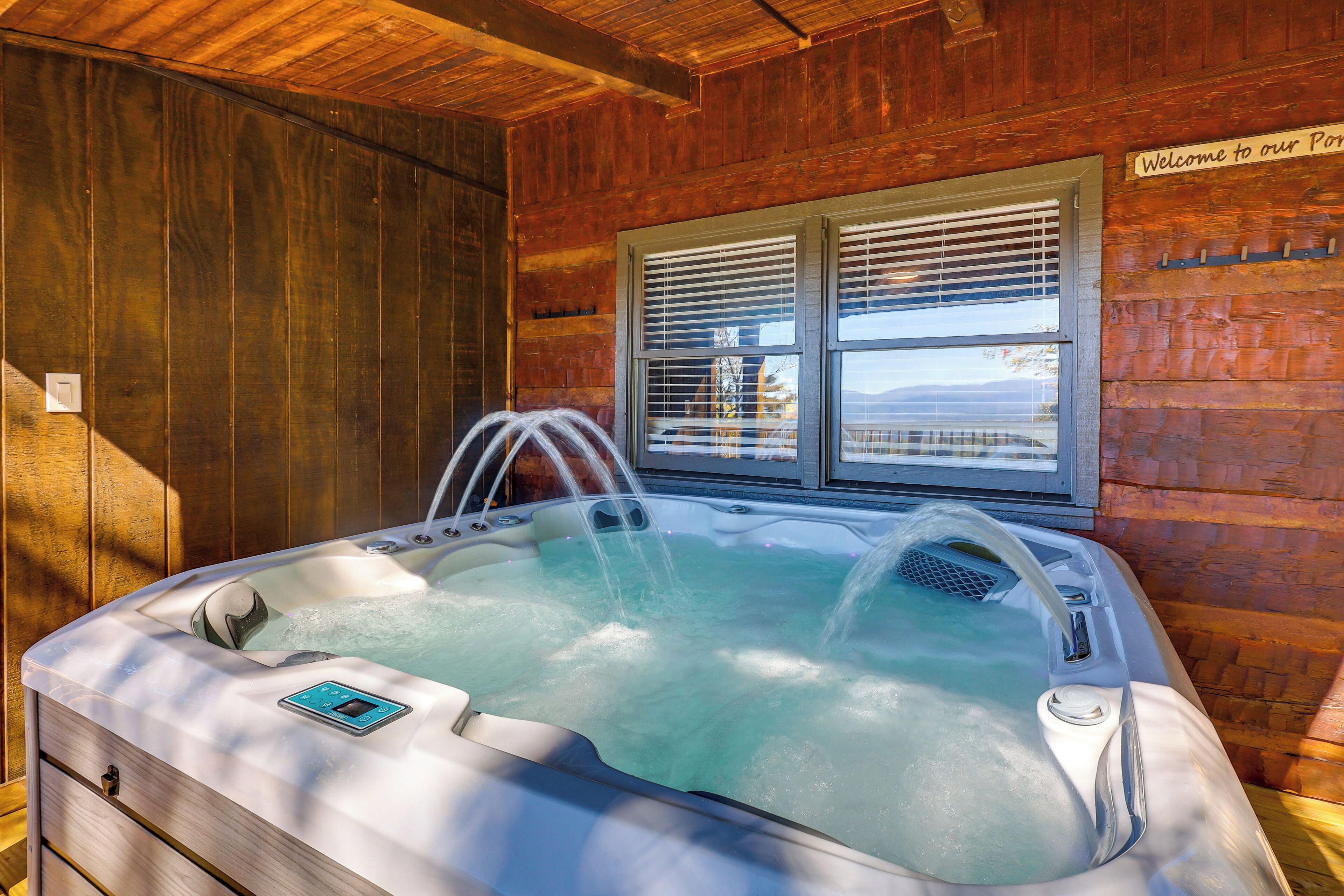 A hot tub in a wooden cabin with a window and a sign saying "Welcome to our Port."