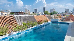 A rooftop swimming pool with a cityscape view, terracotta roof tiles, and potted plants. - w Fantastic House w Amazing Pool in Cartagena (Cartagena)