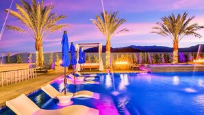 A swimming pool with a water feature and lounge chairs, surrounded by palm trees and a view of the mountains. - The Royal Bahamian- Pickleball Golf Sleeps 20 (Indio)