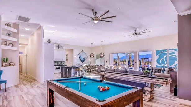 A spacious living area with a pool table, ceiling fans, and a view of the outdoors. - The Royal Bahamian- Pickleball Golf Sleeps 20 (Indio)