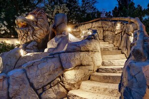 A rock formation with a lion statue and a staircase.
