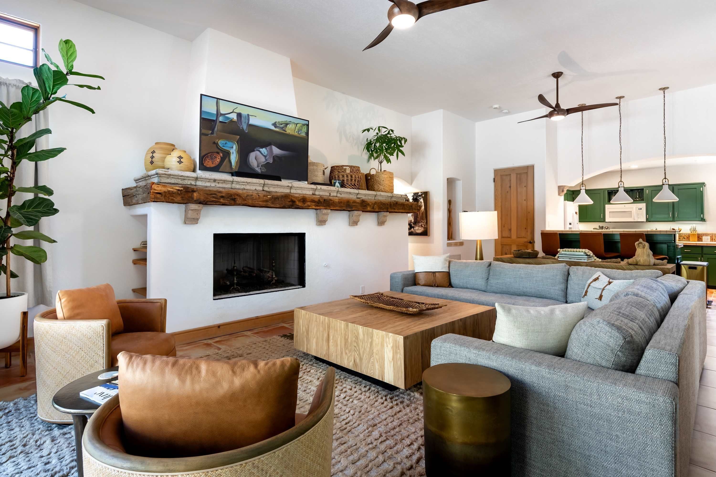 A modern living room with a fireplace, a sofa, a coffee table, and a television.