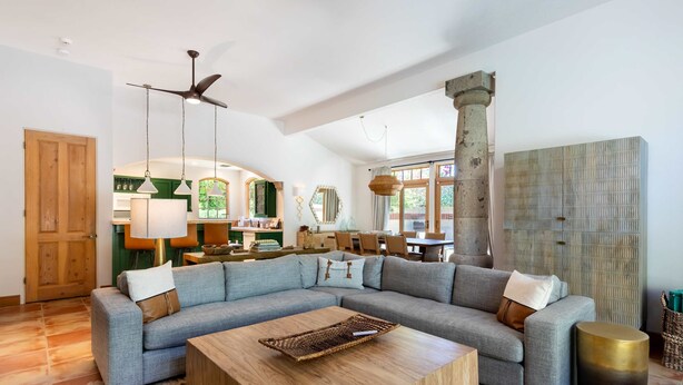A spacious living room with a large L-shaped sectional sofa, a wooden coffee table, and a ceiling fan. - LUX - Historic Tennis Club Enclave - King Beds (Palm Springs)