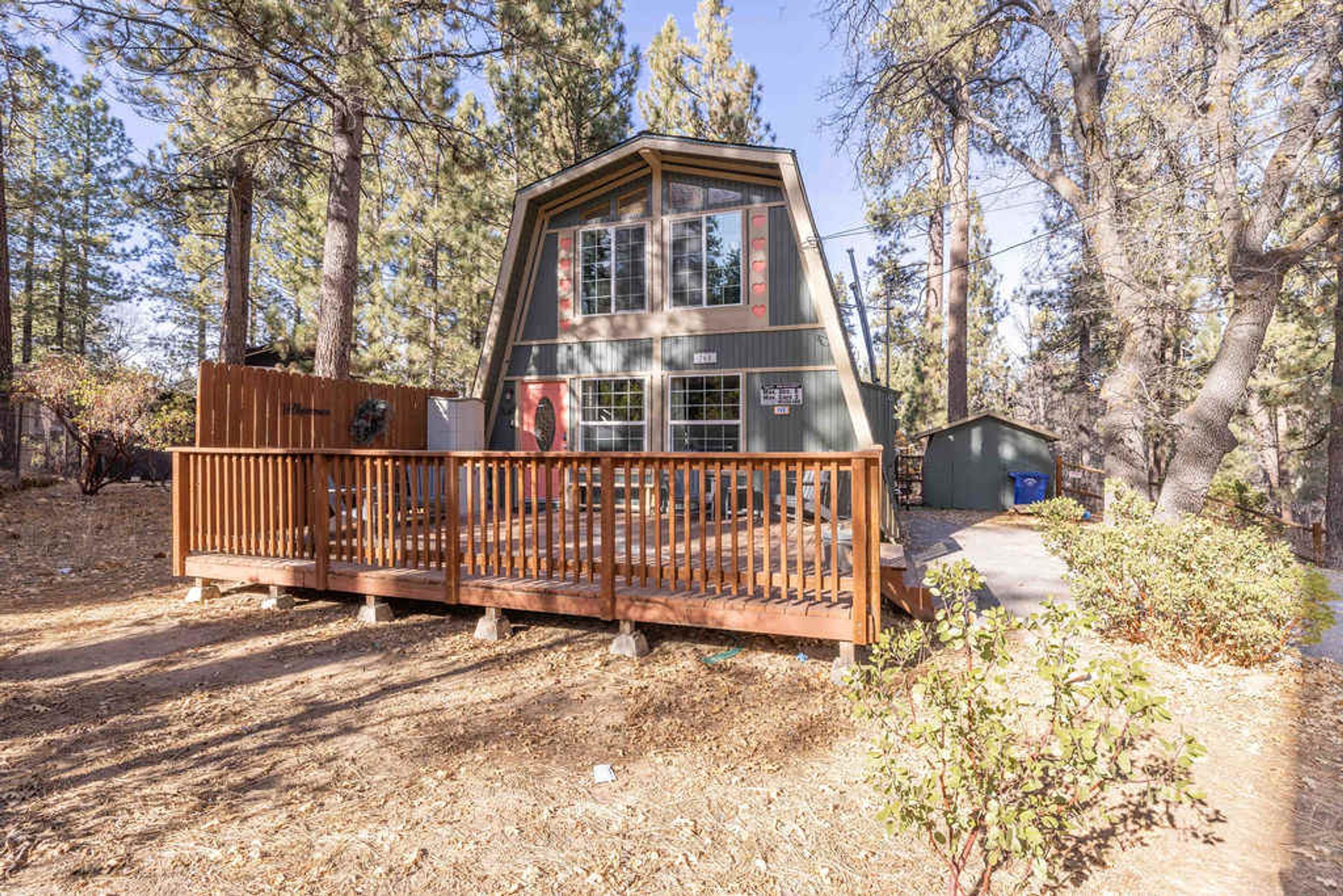 Eine Holzhütte mit einer Holzterrasse, umgeben von Bäumen.