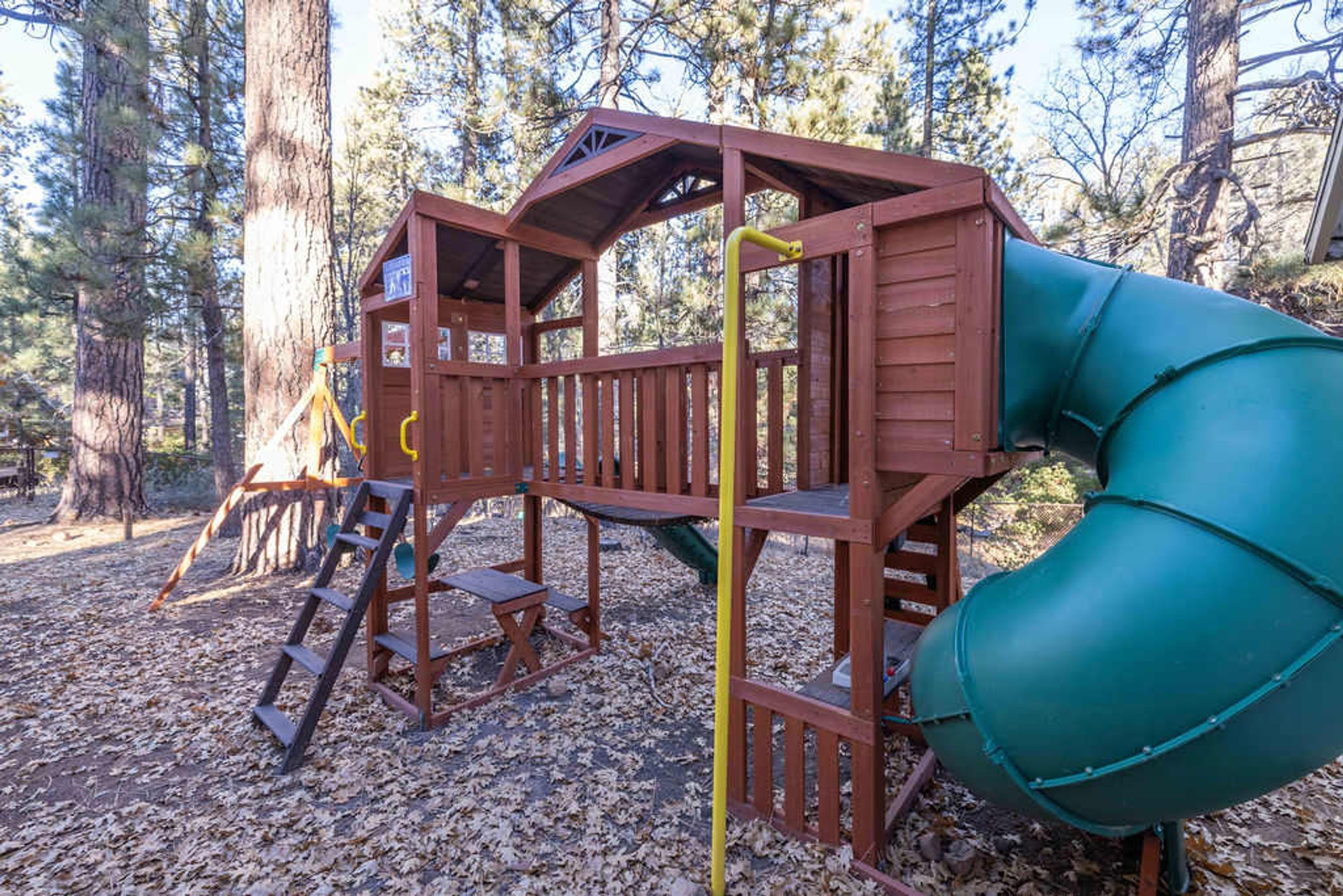 A wooden play structure with a slide and a ladder.