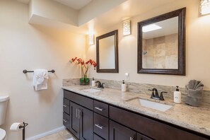 A bathroom with a marble sink, dark cabinets, a large mirror, and a towel rack. - Relax at the 3BR Tranquil Oasis in Palm Springs (Palm Springs)