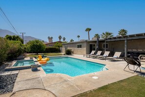 A swimming pool with lounge chairs and a small garden area. - Relax at the 3BR Tranquil Oasis in Palm Springs (Palm Springs)