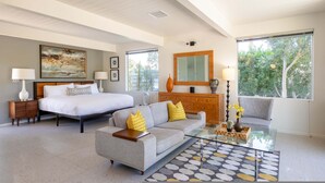 A modern bedroom with a bed, a sofa, a glass coffee table, and a dresser. - Lux Desert Retreat 4BR Pool Spa Stunning Views (Palm Springs)