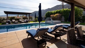 A swimming pool with lounge chairs and umbrellas, surrounded by a garden and mountains in the background. - Movie Colony Oasis - Peaceful Walk to Downtown (Palm Springs)
