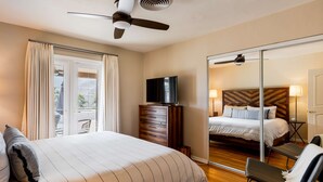 A hotel room with a large bed, a television, a wooden dresser, a chair, and a sliding glass door leading to a balcony. - Movie Colony Oasis - Peaceful Walk to Downtown (Palm Springs)