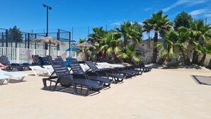 A beachside lounge with rows of sun loungers and a palm tree backdrop. - CAP VALRAS Les sables du midi (Valras-Plage)