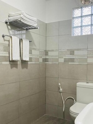 Een douche, handdoeken, zeep, shampoo