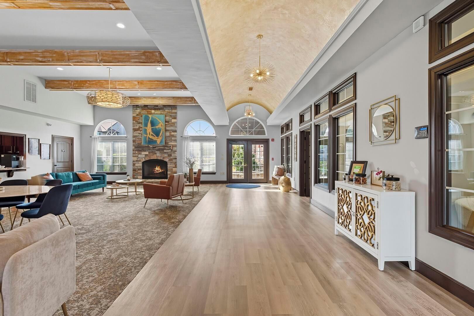 A spacious living area with a fireplace, a dining area, and a hallway leading to a conservatory.