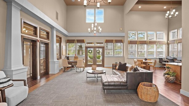 A spacious living area with a fireplace, comfortable seating, and large windows offering views of the outdoors. - Landing | Amazing 2BD, Courtyard, Gym (Broken Arrow)