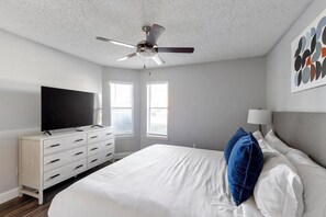 A bedroom with a bed, a dresser, a television, a ceiling fan, and a window. - Landing | Beautiful 1BD, Gym, Courtyard (Grand Prairie)